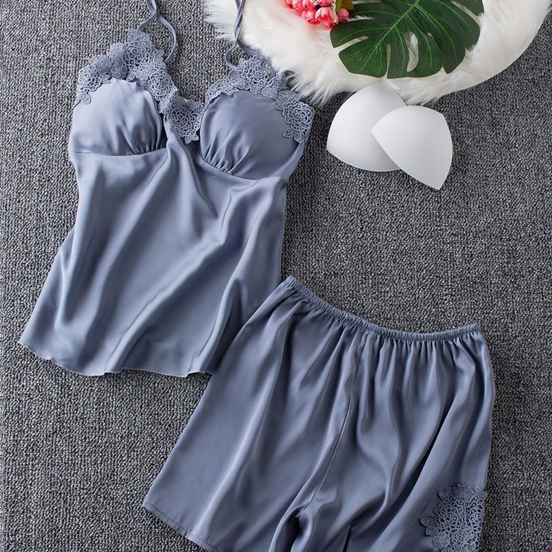 Women’s dusty‑blue satin camisole‑shorts pajama set, thin spaghetti straps, V‑neck decorated with hollow floral lace, built‑in removable padded cups, elastic‑waist shorts with matching lace appliqué on side hem, smooth lustrous satin fabric, simple elegant ladies sleep loungewear.