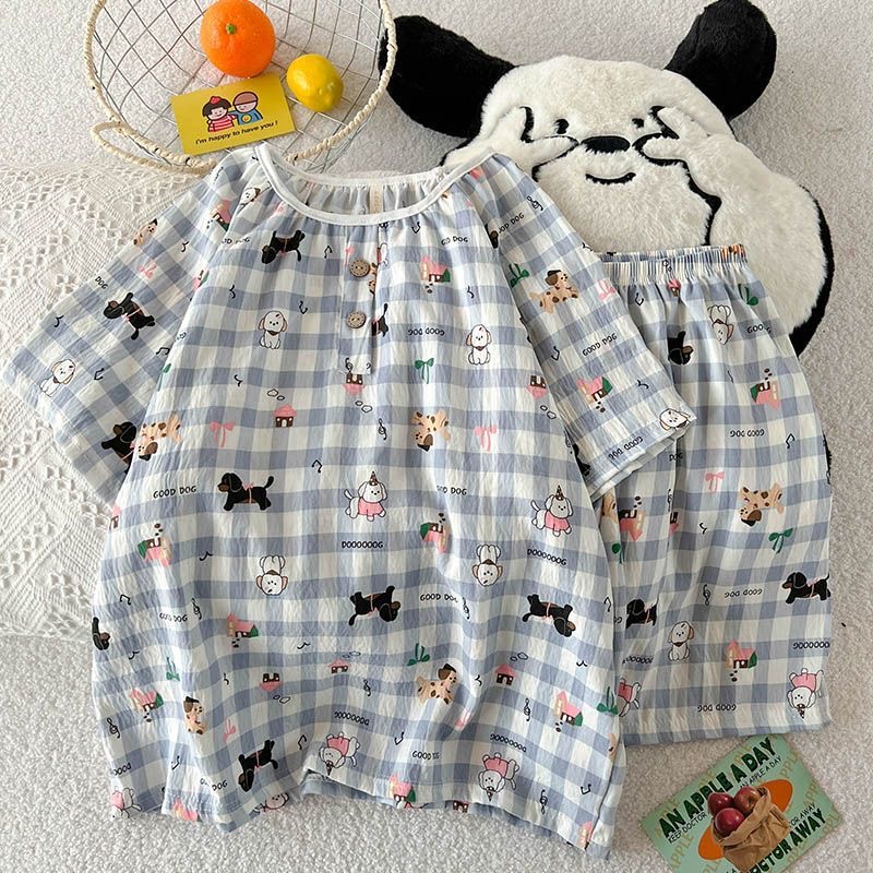 Women’s blue‑white gingham puppy‑print two‑piece pajama set, made of crinkled breathable fabric. Short‑sleeve top comes with elastic round neck and partial button placket, decorated with varied cartoon dog illustrations, bows and small‑house motifs. Matching elastic‑waist shorts, loose relaxed cut, fresh cute style for home wear.